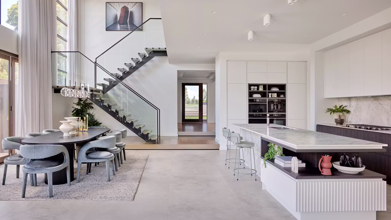 Bright Maplewood kitchen and dining interior with a glass staircase