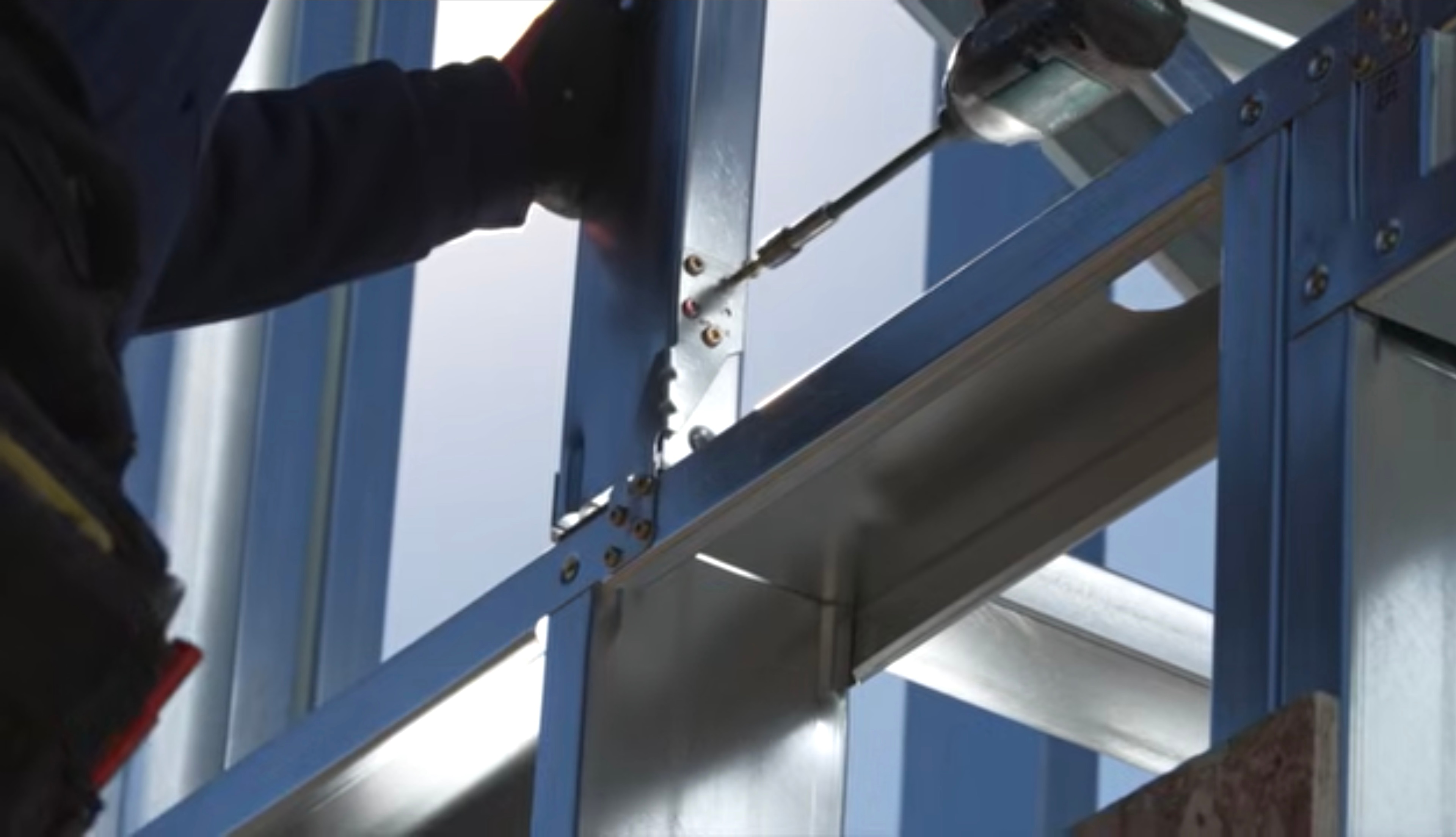 Close view of precision fastening during steel-frame assembly